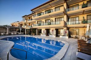 a hotel swimming pool in front of a building at Rigas Boutique Hotel & Spa in Afitos
