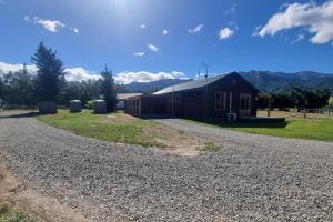 a barn on the side of a gravel road at Sherwood Ranch Cottages - 403 Woodbank Road in Hanmer Springs