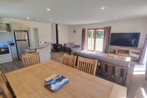 a kitchen and a living room with a table and chairs at Sherwood Ranch Cottages - 403 Woodbank Road in Hanmer Springs