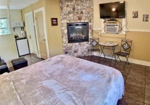 a bedroom with a large bed and a stone wall at Tuscany Dream Rock Cottage/#8 in Eureka Springs