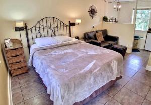 ein Schlafzimmer mit einem großen Bett und einem Stuhl in der Unterkunft Tuscany Dream Rock Cottage/#8 in Eureka Springs