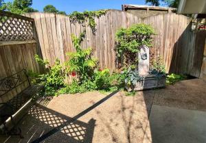 einen Garten mit einem Zaun und einer Statue im Hof in der Unterkunft Tuscany Dream Rock Cottage/#8 in Eureka Springs