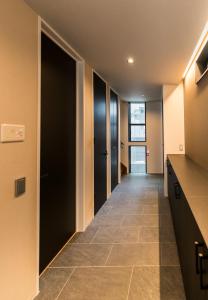 a hallway with black doors and a tile floor at Flower Base Fuji in Muromimachi +66 photos