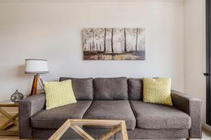 sala de estar con sofá gris y almohadas amarillas en Abbotsford Short Stay Luxury Style & Location, en Melbourne