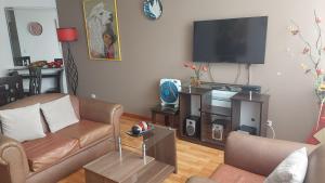 sala de estar con sofá y TV de pantalla plana en Departamento Temporal Pardo, en Lima