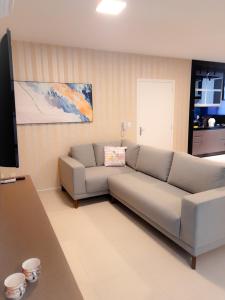 ein Wohnzimmer mit einem Sofa und einem Flachbild-TV in der Unterkunft Apto novo no centro in Pomerode