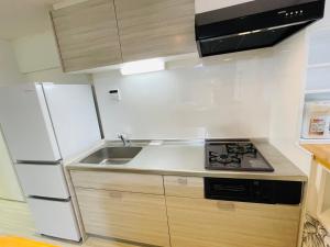 a kitchen with a white refrigerator and a sink at ROYAL YONEGAHAMA ｌ米が浜通 in Kusugaurachō