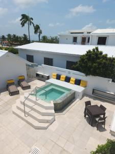 a building with a pool and a table and chairs at Villa Boscardi in Belize City