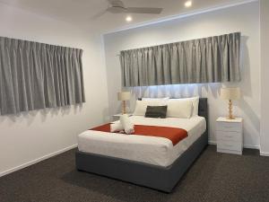 a bedroom with a large bed and two windows at Iluka Motel in Iluka