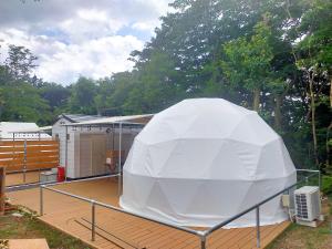 a large white tent sitting on top of a deck at K‘ｓCAMP伊豆高原　グランピング in Futo