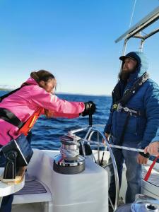 Liveaboard sailing tour in Harstad islands في هارستاد: رجل وامرأة على متن قارب