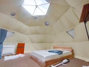 um quarto com uma cama numa tenda em K‘ｓCAMP伊豆高原　グランピング em Futo