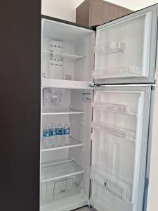 Departamento Ciudad MayaKoba 2 habitaciones في بلايا ديل كارمن: ثلاجة مفتوحة فيها زجاجات ماء