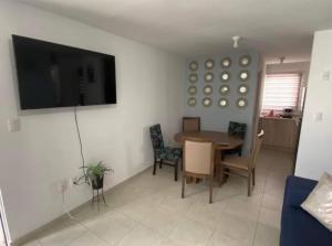 uma sala de estar com uma mesa e uma televisão na parede em Departamento-Poliforum Feria Estadio Zona Piel. em León