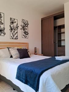 Departamento Ciudad MayaKoba 2 habitaciones في بلايا ديل كارمن: غرفة نوم بها سرير كبير وبطانية زرقاء +9 صور