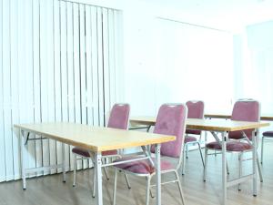 a conference room with two tables and purple chairs at HOTEL LiVEMAX BUDGET Yokohama Kannai in Yokohama