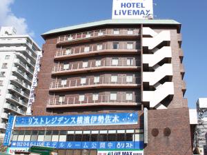 a tall building with a sign on top of it at HOTEL LiVEMAX BUDGET Yokohama Kannai in Yokohama