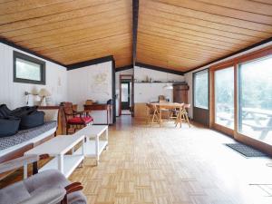 una sala de estar con techos de madera y una habitación con mesas. en Holiday home Melby IX, en Melby