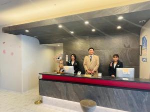 a group of people standing at a counter at The Premium Hotel In Rinku in Izumi-Sano