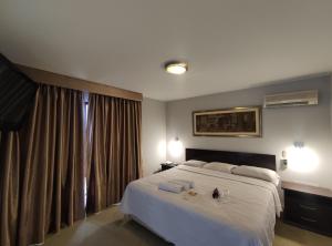 a bedroom with a large white bed and a window at Inti Llaqta Hotel & Suites in Lima