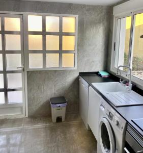 a laundry room with a sink and a washing machine at Casa Las Emilias en La Cañada in Partida de La Cañada