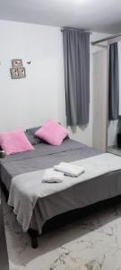 two beds in a room with pink towels on them at La Katiritaa in Villavicencio