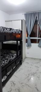 Zimmer mit 2 Etagenbetten und einem Fenster in der Unterkunft La Katiritaa in Villavicencio