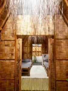 a room in a bamboo house with two beds at Apache surf villa in San Isidro