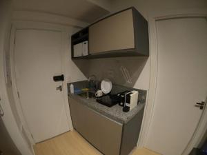 a small kitchen with a sink and a microwave at Aconchegante Apartamento Itaim B- Vila Nova in Sao Paulo