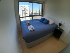 a bedroom with a large bed with towels on it at Aconchegante Apartamento Itaim B- Vila Nova in Sao Paulo