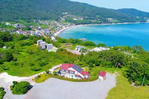 una vista aérea de una casa en una colina junto al océano en Travel Sketch Pension en Geoje 