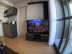 a living room with a flat screen tv on a wall at Aconchegante Apartamento Itaim B- Vila Nova in Sao Paulo