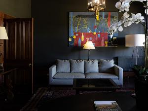 a living room with a couch and a painting at Cleveland Estate in Lancefield