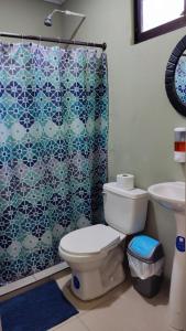 a bathroom with a toilet and a shower at Casa Black Chaini in Puerto Viejo