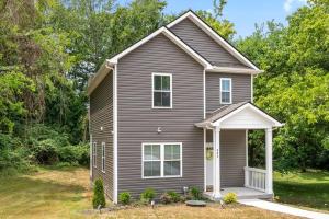 una casa marrone con una porta bianca in un cortile di One-Of-A-Kind Smart, Cookie Themed Home For Up to 6 a Clarksville