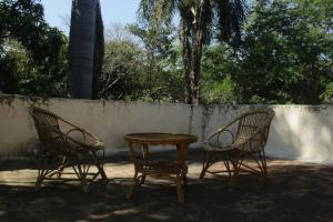 two chairs and a table in front of a wall at Hacienda la Luna in Tetecala