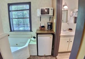 un piccolo bagno con vasca e forno a microonde di D'vinery Rock Cottage/ #6 a Eureka Springs