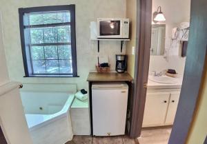 a small bathroom with a tub and a microwave at D'vinery Rock Cottage/ #6 in Eureka Springs