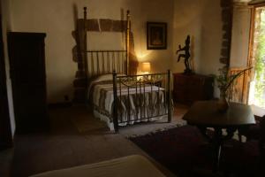 a bedroom with a bed and a table and a window at Hacienda la Luna in Tetecala +1 photo