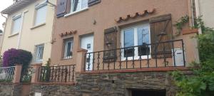a brick building with a balcony with windows at Adorable maison dans le port in Port-Vendres