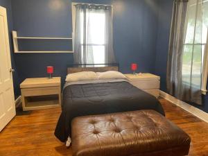a bedroom with a bed with a leather ottoman and a window at fashionably cozy place in Meriden