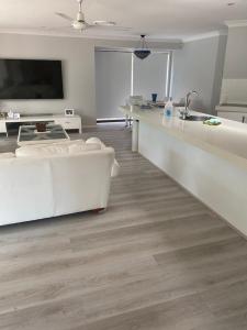 a living room with a white couch and a sink at Mermaid Waters 3 Bedroom Home Free Wifi - Close to the beach - shops in Gold Coast