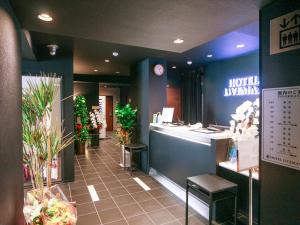 una camera d'albergo con una zona di attesa con piante di HOTEL LiVEMAX Yokohama Kannai Ekimae a Yokohama