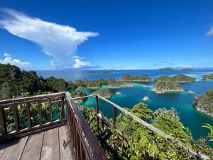a bridge over a river with rocks in the water at Tour raja Ampat paradise in Minyaifuin