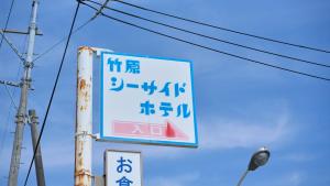 um sinal com escrita chinesa ao lado de um poste em Tabist Setouchinoyado Takehara Seaside em Takekara