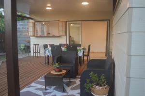 een patio met stoelen en een tafel en een keuken bij Kai Palmer Lodge in Punaauia