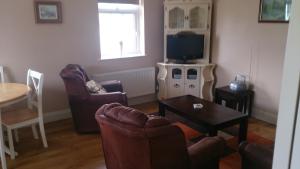 a living room with two chairs and a television at Villa Pio Luxury Apartment 3km from historic Cong, Ashford Castle, Ashford Lodge in Cong