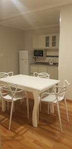 uma mesa branca e cadeiras numa cozinha em Hotel Azul Junin em Junín