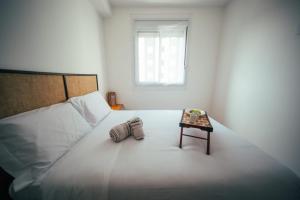 um quarto branco com uma cama e uma mesa em Apartamento confortável próximo ao Transamérica Expo em São Paulo