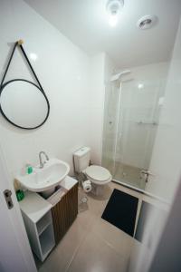 y baño con lavabo, aseo y ducha. en Apartamento confortável próximo ao Transamérica Expo, en São Paulo